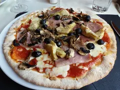 Pizza med skinke, artiskokker, sorte oliven og champignon på tomat og mozzarella